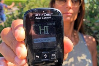 Woman holding blood glucose meter with HI reading